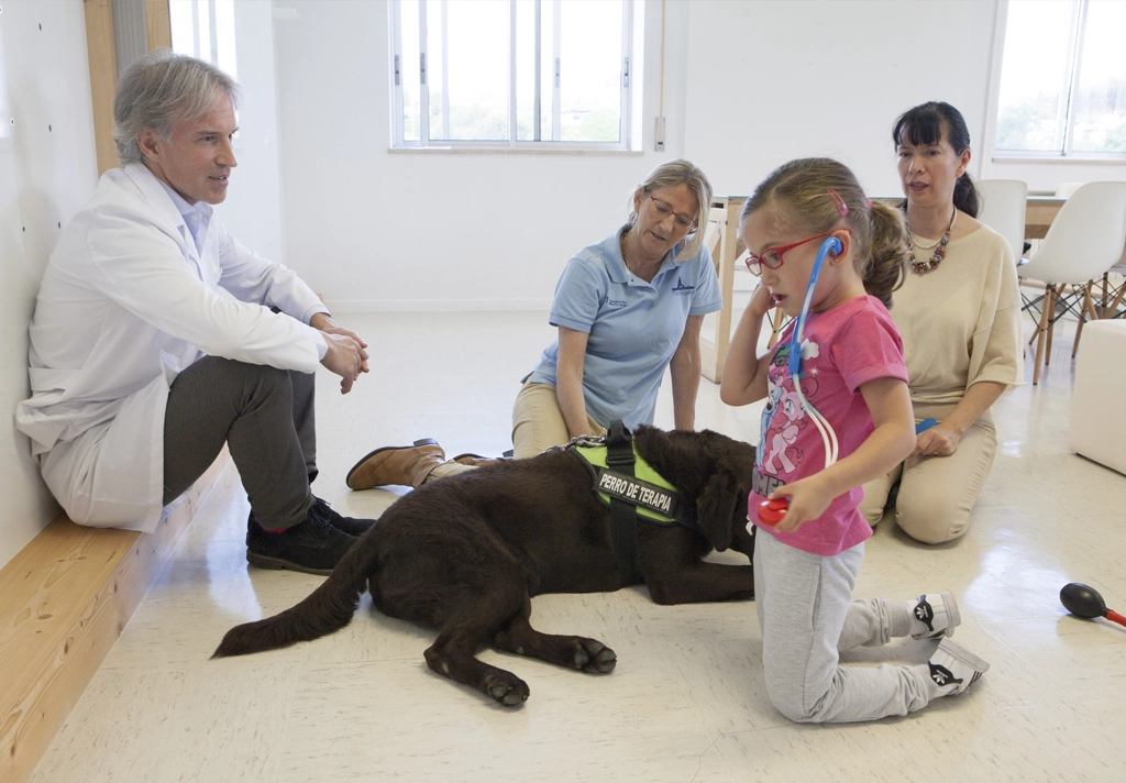 Niña interactuando con perro de terapia
